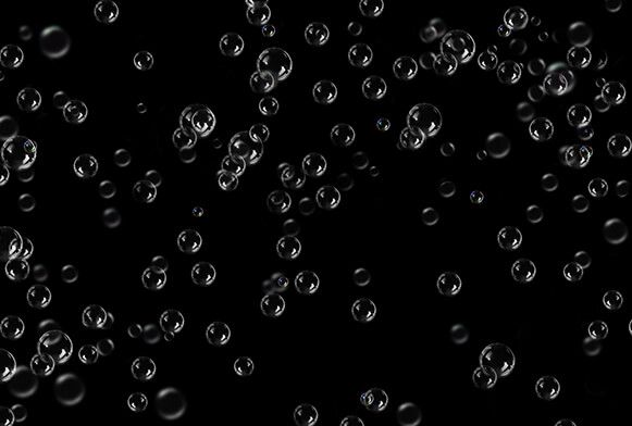 many bubbles floating in the air on a black background