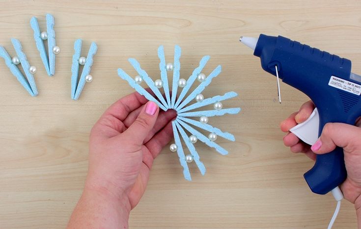 a person is using glue to decorate flowers with pearls on the stems and pins attached to them