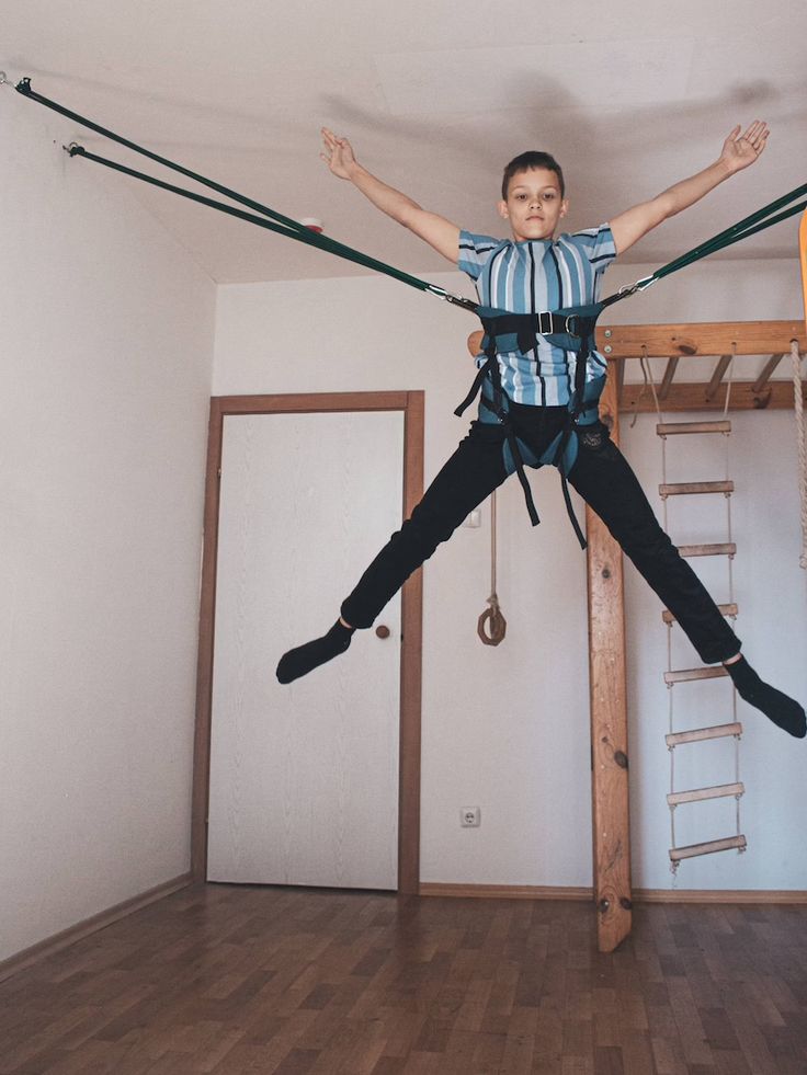 a young boy is suspended in the air by ropes