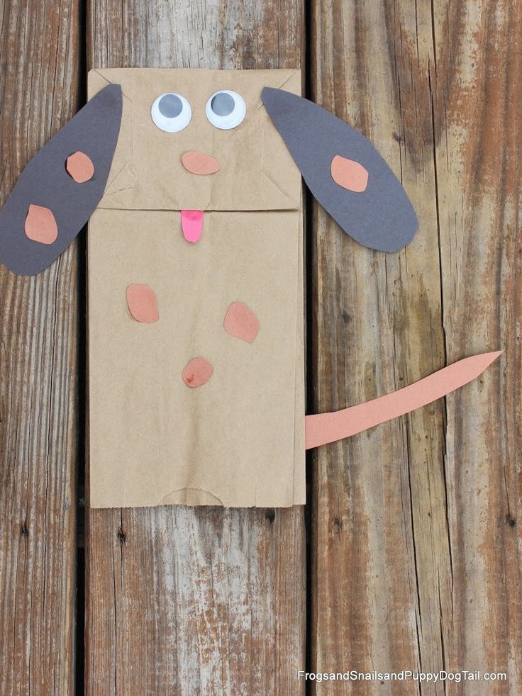 a brown paper bag with a dog cut out of it on top of a wooden table