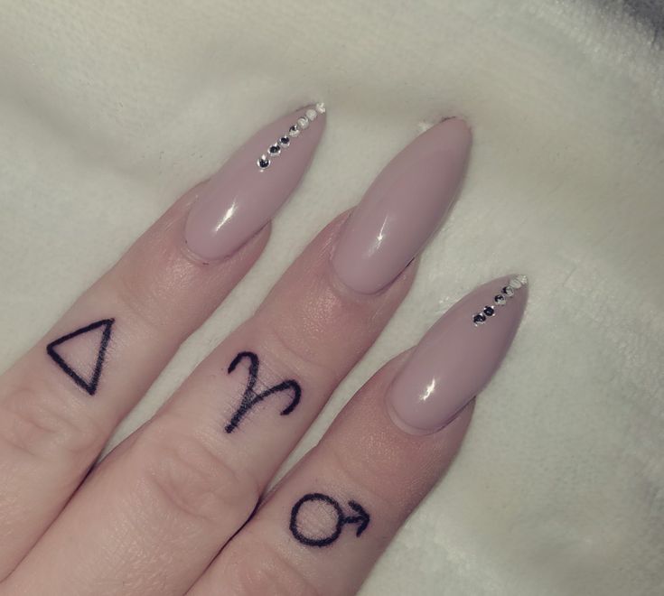 two fingers with tattoos on them, one has an arrow and the other has numbers