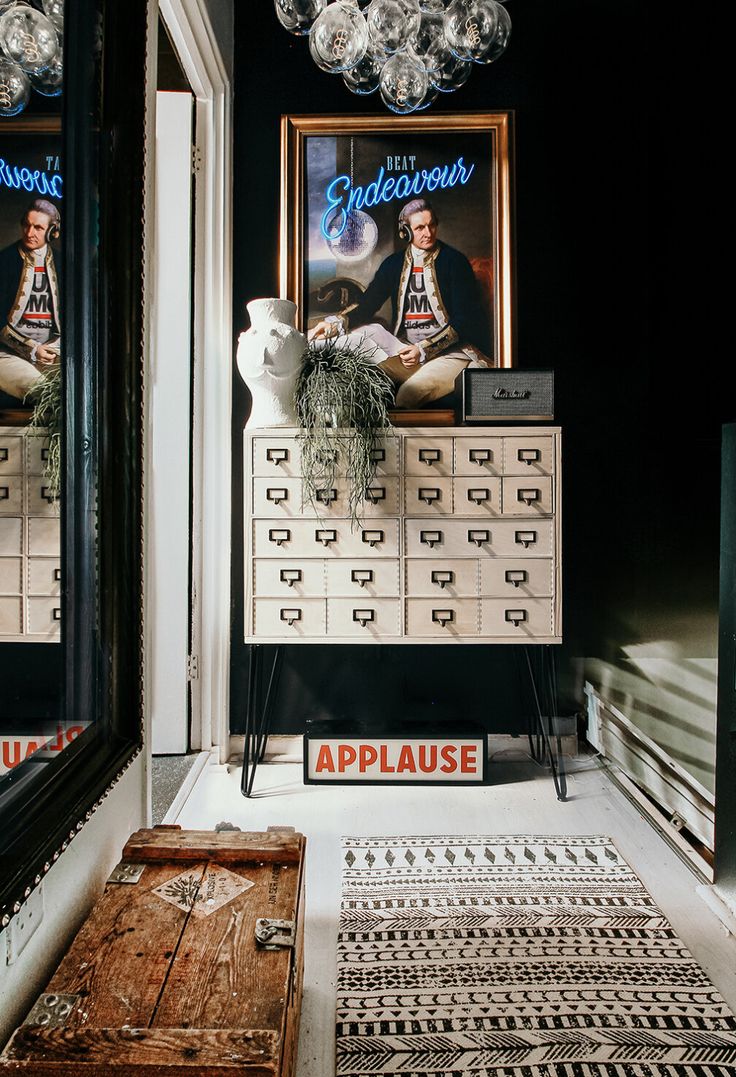 an advertisement for applause is displayed in front of two mirrors and a chest of drawers