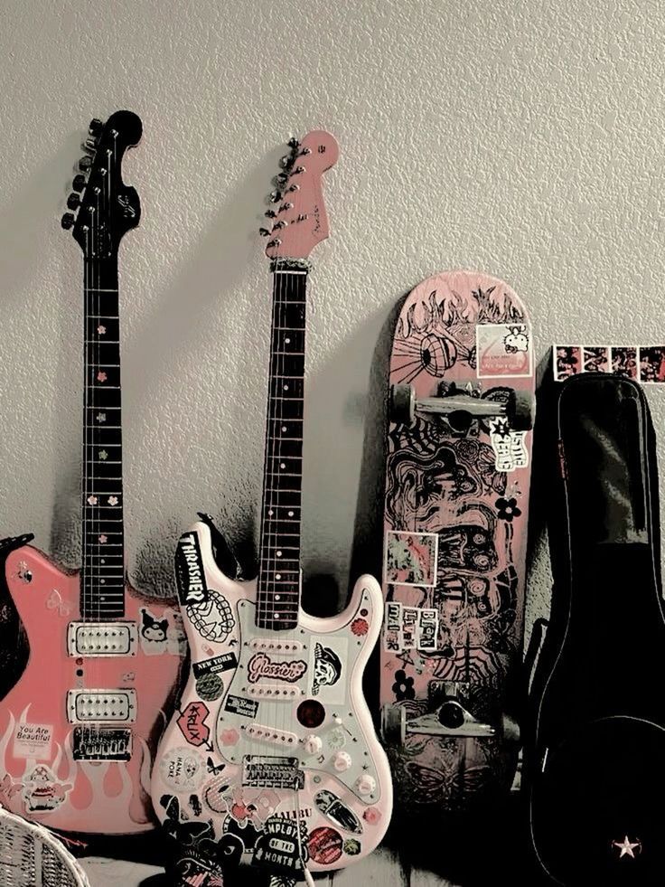 three guitars are lined up next to each other with stickers on the wall behind them