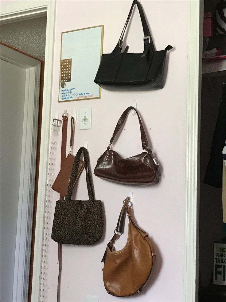 several purses hanging on the wall next to each other