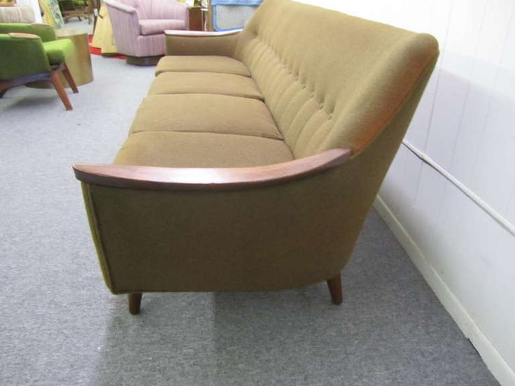 a brown couch sitting on top of a carpeted floor next to a white wall