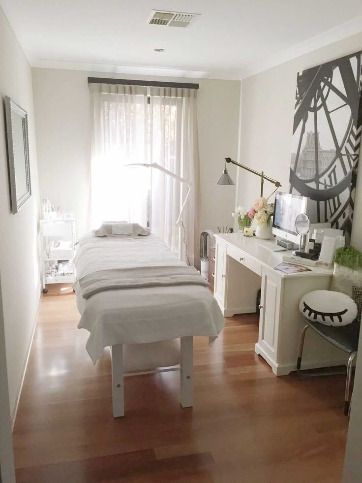 a white bed sitting next to a window in a bedroom on top of a hard wood floor