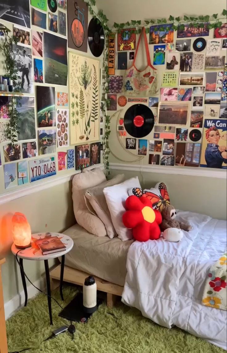 a bed with lots of pictures on the wall and a red stuffed animal sitting on top of it