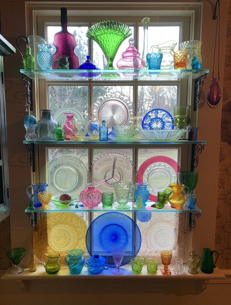 a shelf filled with lots of colorful glassware