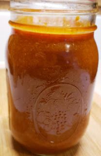 a jar filled with liquid sitting on top of a wooden table