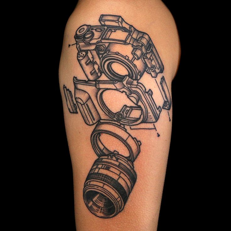 a black and white photo of a camera tattoo on the arm