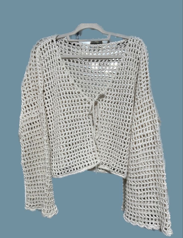 a white knitted jacket on a hanger