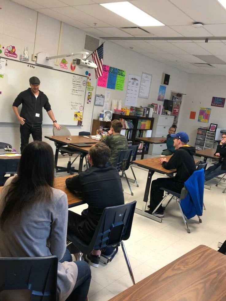 a group of people sitting at desks in a classroom