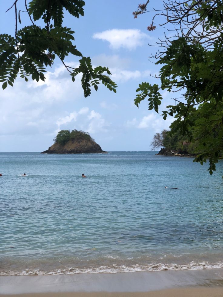 people are swimming in the ocean near an island