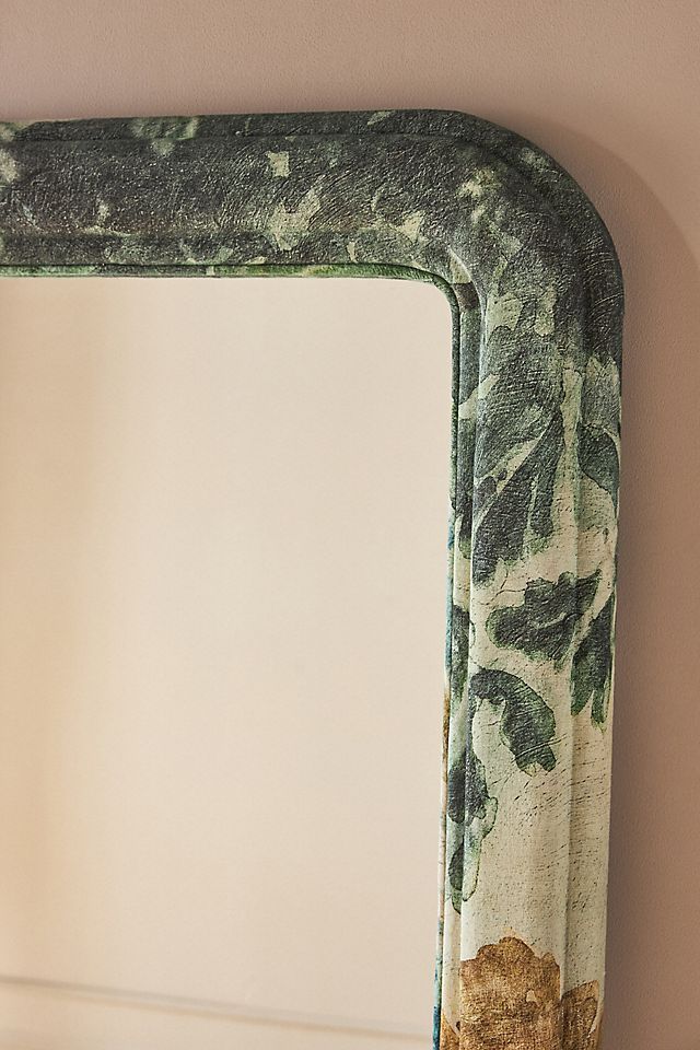 a mirror sitting on top of a shelf next to a wall