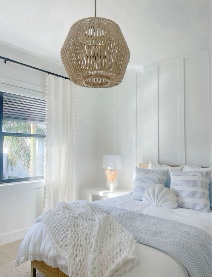 a bedroom with a bed, lamps and curtains in it's windowsills