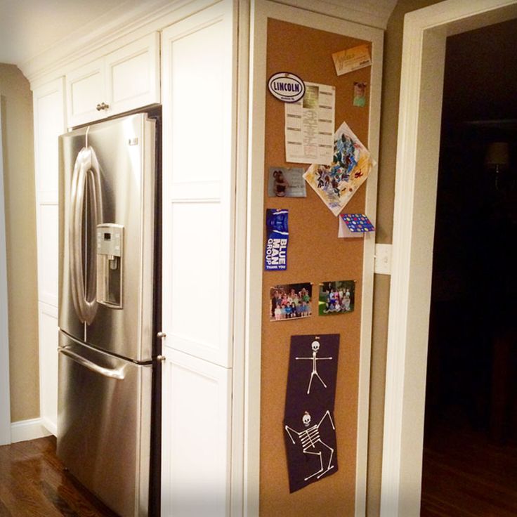 a refrigerator with magnets and pictures on the wall next to it's door