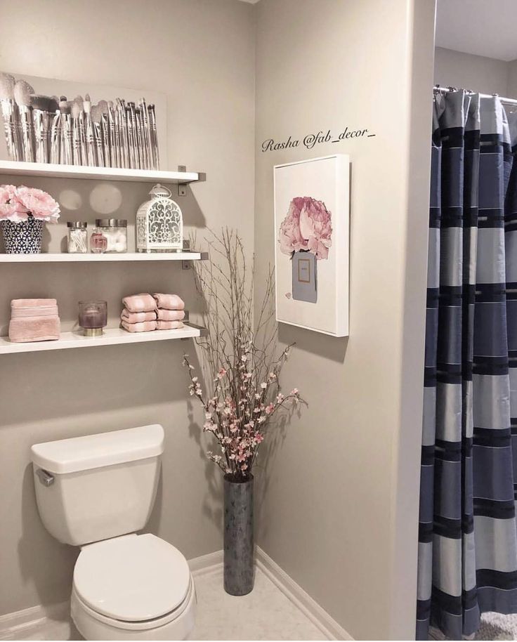 a white toilet sitting in a bathroom next to a shelf filled with pink and blue items