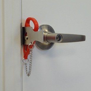 an open door with a pair of scissors hanging from it's handle and chain