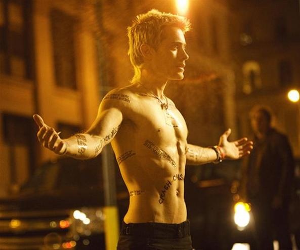 a shirtless man standing in the street with his arms spread out and hands outstretched