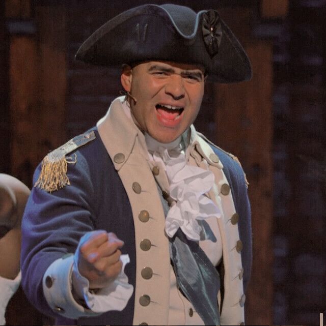 a man in a pirate costume is pointing at something with one hand and his mouth open