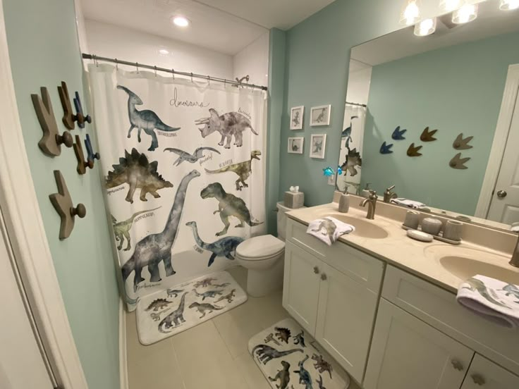 a bathroom with dinosaurs on the shower curtain