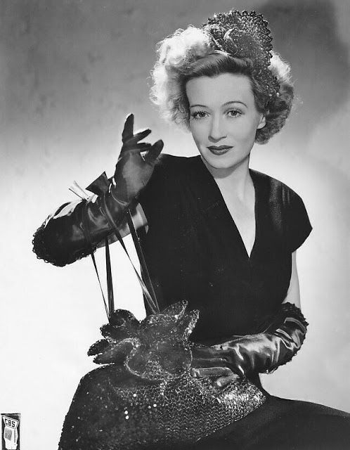 a black and white photo of a woman with gloves