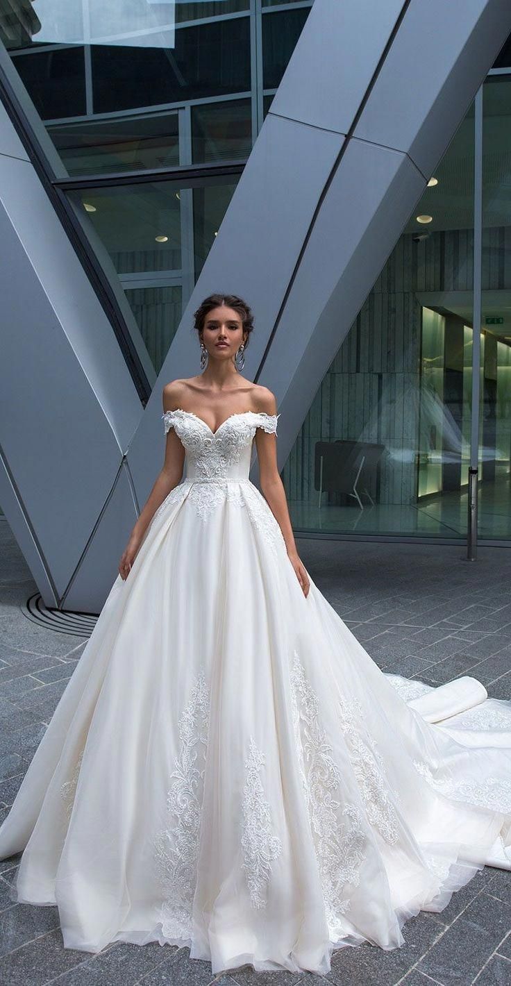 a woman in a white wedding dress posing for the camera with her hands on her hips