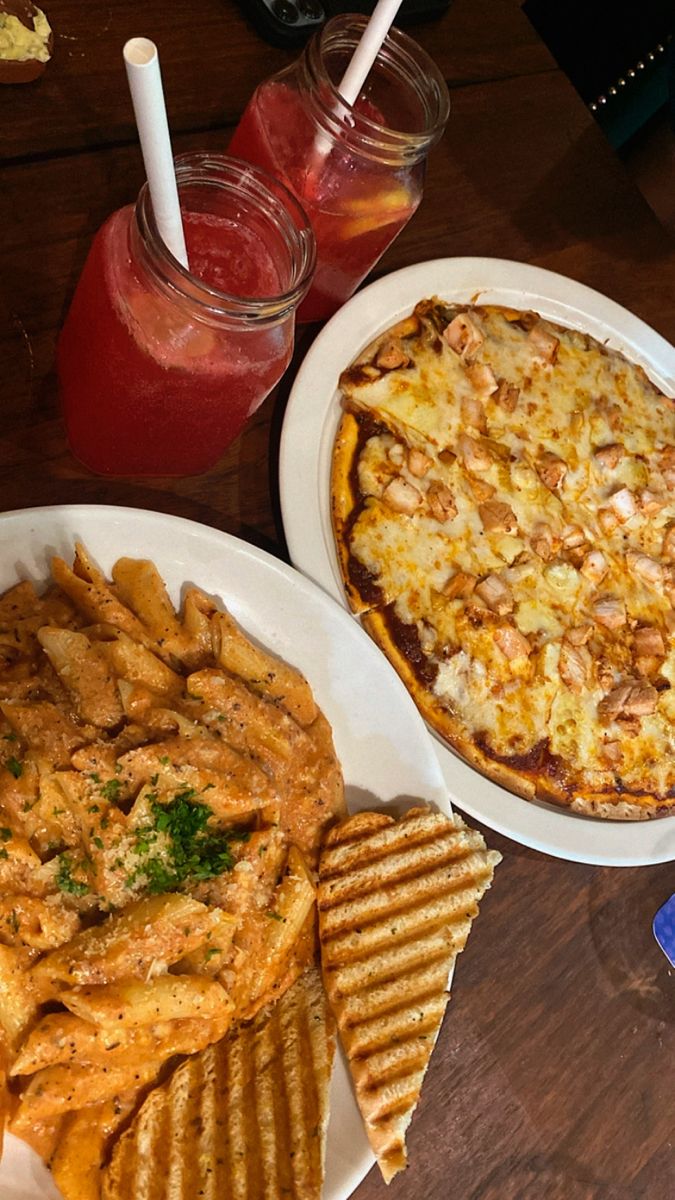 there is a pizza, french fries and soda on the table next to each other