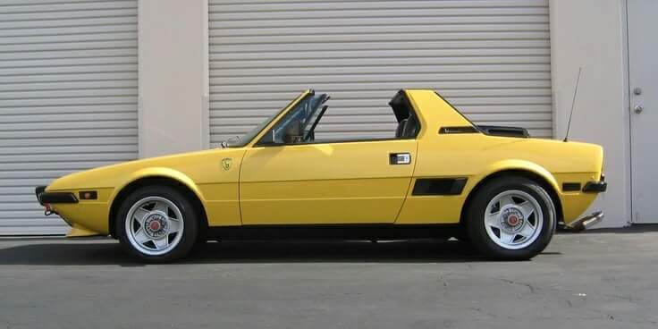 a yellow sports car parked in front of a garage door