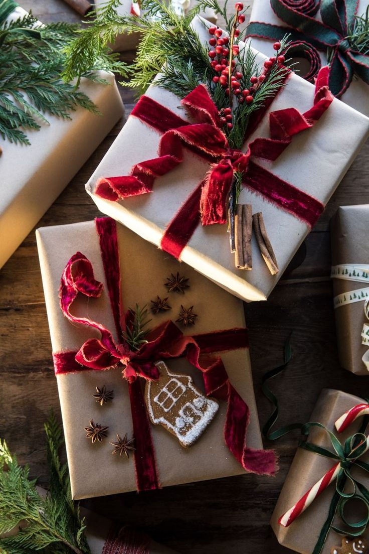 christmas presents wrapped in brown paper and tied with red ribbon on top of wooden table