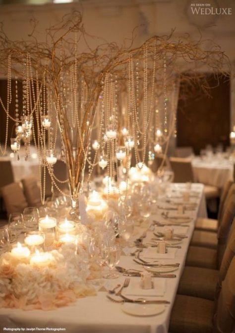 a long table with many candles and flowers on it, all set up for a formal function