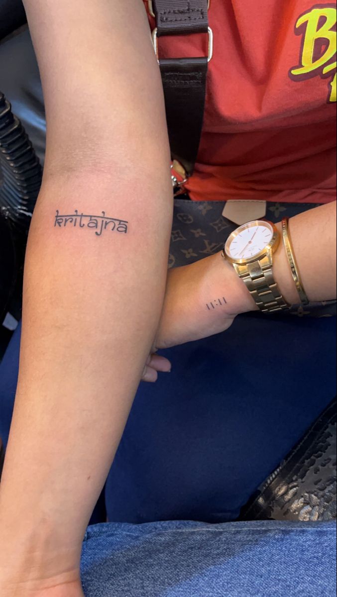 a person with a wrist tattoo that says,'india'on the side of their arm