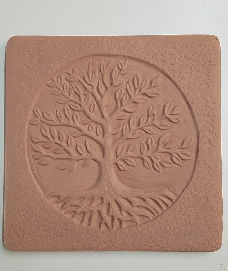 a clay carving of a tree with leaves on it's trunk and branches in the center