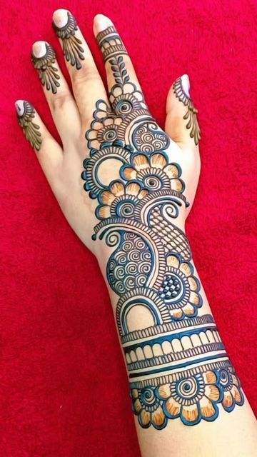 a woman's hand with henna tattoos on it