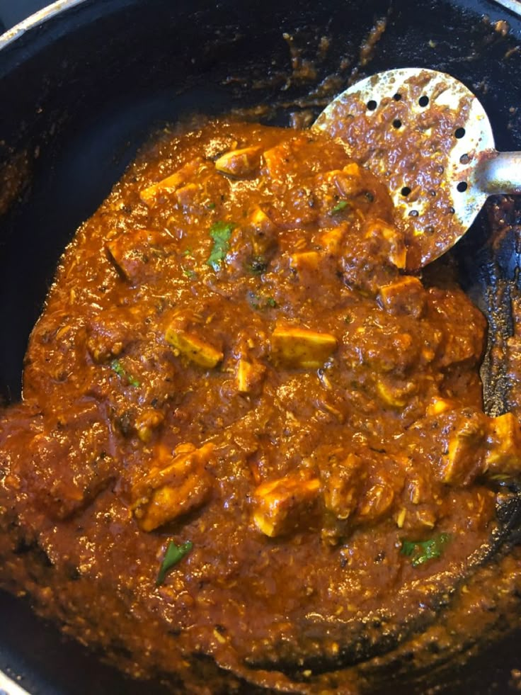 a skillet with some food in it and a spatula on the side,