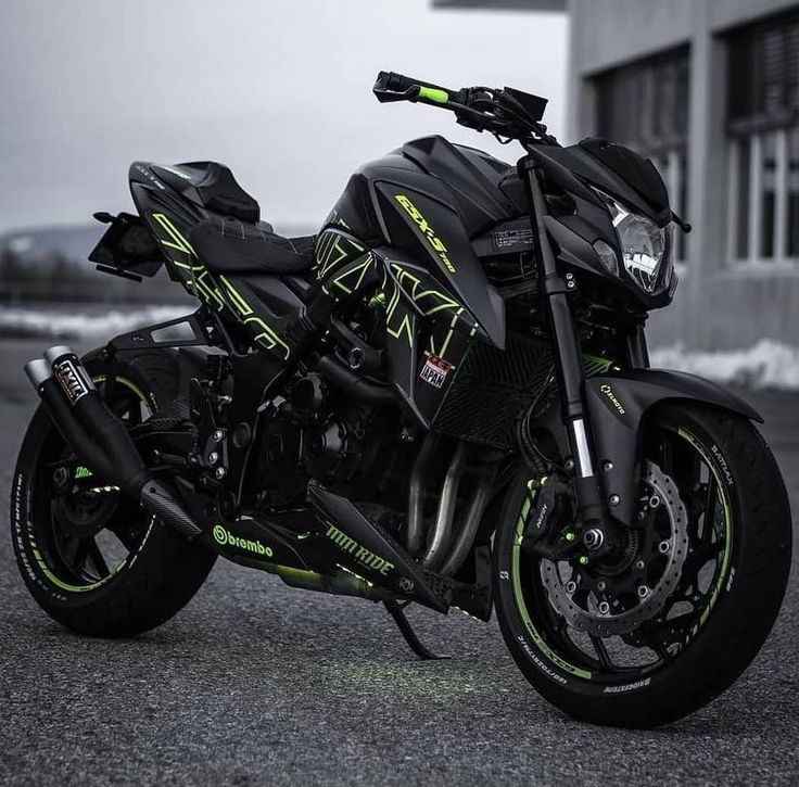 a black and green motorcycle parked in front of a building