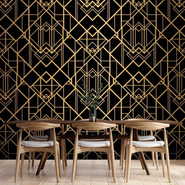 a dining table with four chairs and a vase on it in front of a black wall