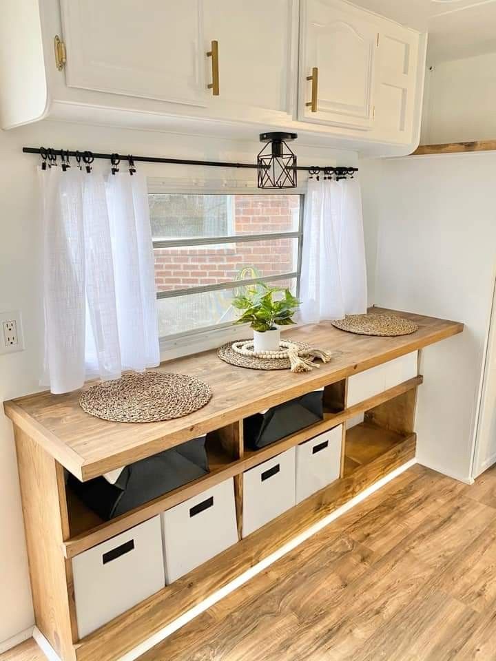 the inside of a trailer with storage drawers and cabinets on it's sides, in front of a brick wall