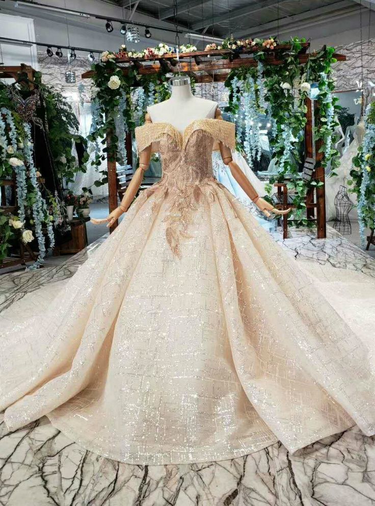 a dress on display in a room with flowers and greenery around the neckline