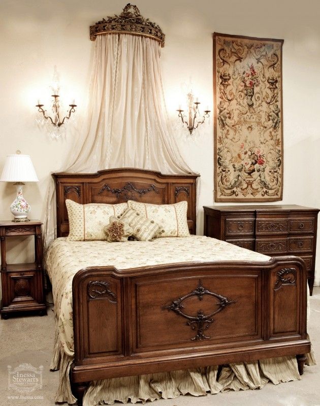 a bedroom with a bed, nightstands and chandelier