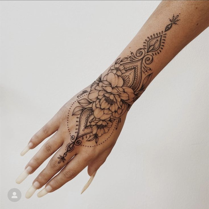 a woman's hand with a flower tattoo on the middle of her left arm