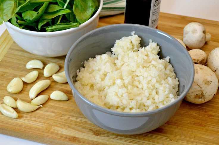 the ingredients to make this dish include rice, spinach and mushrooms on a cutting board