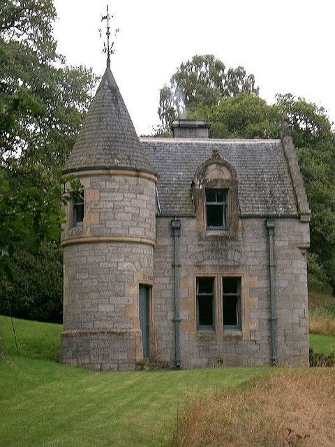 an old stone building with a clock on the top of it's roof and windows