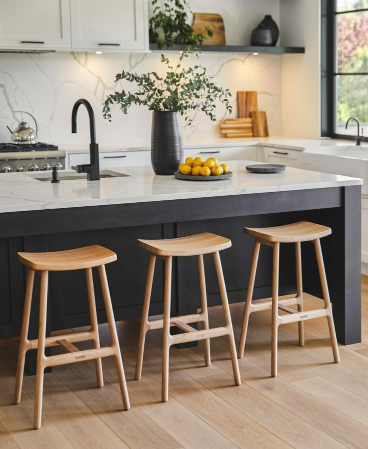 three stools sit in front of an island with two lemons on the counter