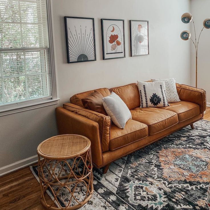 a living room filled with furniture and pictures on the wall next to a large rug