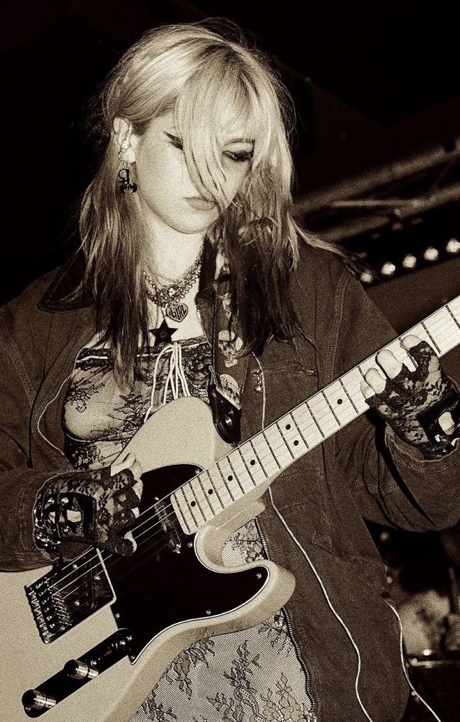 a woman playing an electric guitar on stage