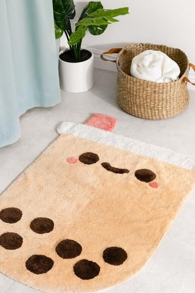 a bathroom with a rug on the floor and a potted plant next to it