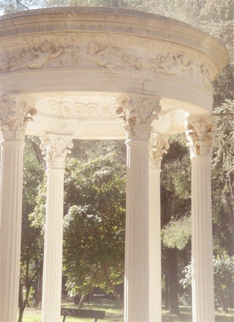 an ornate white gazebo surrounded by trees