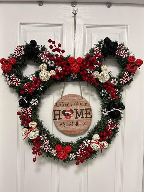 a mickey mouse wreath hanging on a door with the words welcome home written in red, white and black