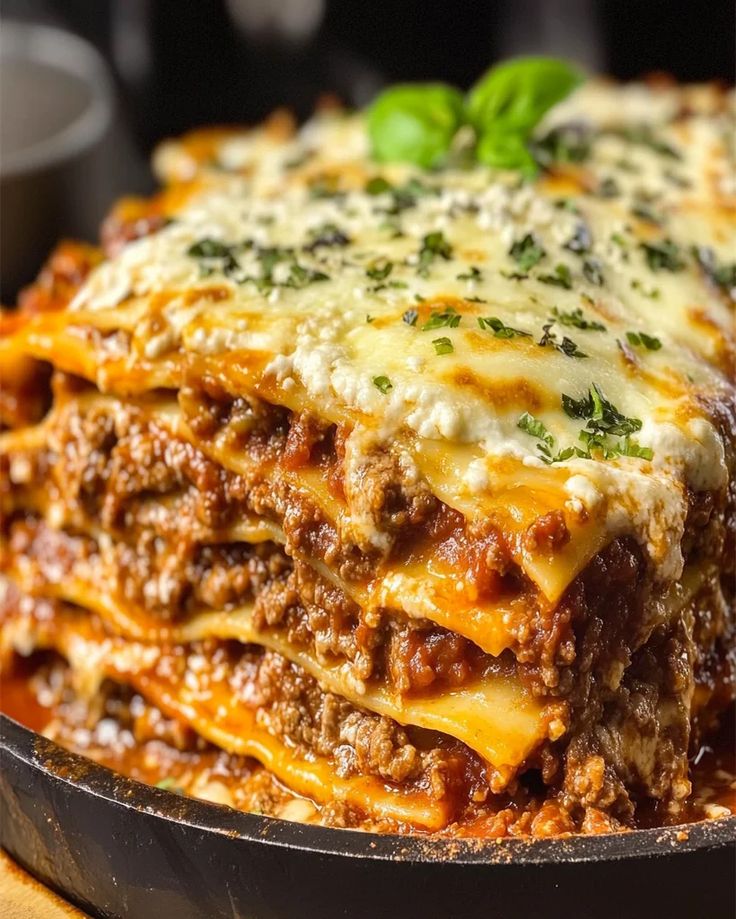 lasagna stacked on top of each other in a skillet with sauce and cheese